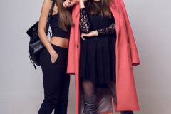 Full height   studio image of two fashionable sexy woman in casual trendy spring coat,  boots with heels , black hat, stylish hand bag.